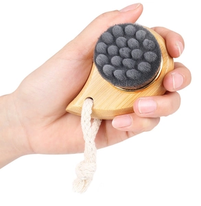 Close-up of facial brush with soft fiber bristles, wooden handle and cotton lanyard