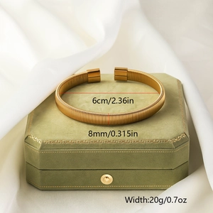Detail showing the 8mm width and 6cm diameter of this textured gold braided bangle