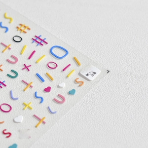 Macro detail of 5D embossed nail stickers featuring colorful 3D lines and heart patterns