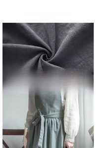 Detailed macro view of natural linen fabric texture and elegant lace trimming on apron