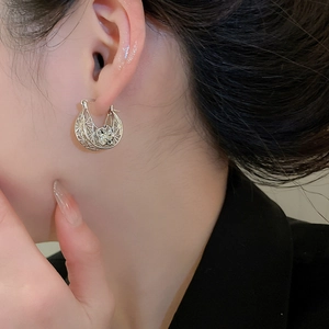 Detail view of silver hollow floral hoop earrings featuring intricate lattice texture
