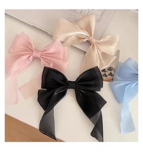 Detail showing oversized translucent organza ribbon bows in pastel pink and blue shades