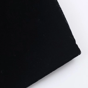 Detailaufnahme der weichen Samttextur und der hochwertigen Nähte des schwarzen Kleides