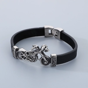 Macro shot of stainless steel motorcycle skull charm on braided leather biker bracelet