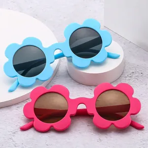 Flower-shaped sunglasses for kids in light blue and pink on white display stands