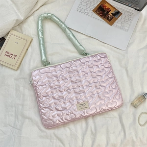 Pink heart quilted laptop sleeve with mint green handles and aesthetic lifestyle props