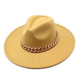 Close-up of mustard yellow wide brim wool fedora hat with a chunky gold chain strap