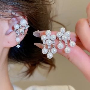 Detail of silver pearl and zircon ear cuff set shown with close-up hand placement