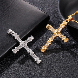 Close-up of gold and silver hip hop cross pendants with sparkling crystal inlay