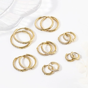 Various sizes of gold hoop earrings with cubic zirconia inlay on white background