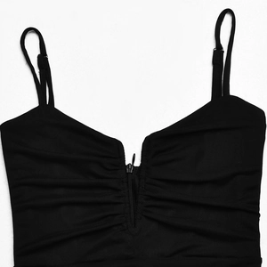 Detailed view of the front zipper closure and ruched sides on this black v-neck dress
