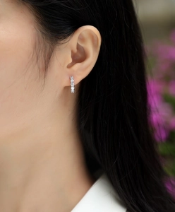 Close-up of S925 sterling silver hoop earrings with sparkling moissanite stones on ear