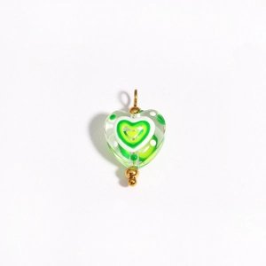 Macro view of green heart-shaped glass bead with gold ring for DIY jewelry making