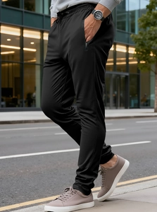 Detail of men's black joggers featuring zip pockets and adjustable drawstring waist