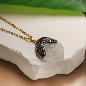 Macro detail of a raw white crystal pendant with multi-color rhinestones and gold chain