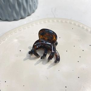 Detail of tortoise shell claw clip with France Handmade lettering on a ceramic tray