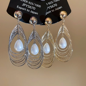 Nahaufnahme von 925er Silber Tropfenohrringen mit Perlen in Gold- und Silberoptik