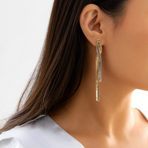 Elegant two-tone spiral tassel earrings in gold and silver finish on a model's ear
