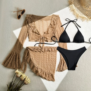 Detail of four-piece black bikini set with brown lace shrug and ruffled sarong wrap
