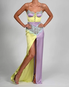 Detail of satin dress featuring yellow and purple contrast with blue lace and high slit