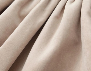 Gros plan détaillé sur la texture du velours abricot avec plis doux et drapé élégant