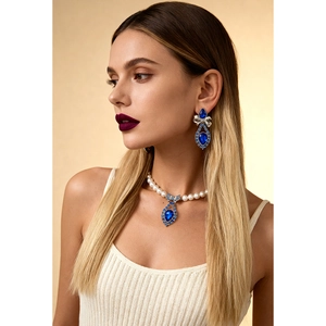 Elegant jewelry set with blue teardrop pendants and pearl necklace on a model