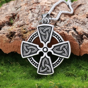 Silberne Keltenkreuz-Halskette mit Triquetra-Symbolen auf rustikalem Rindenhintergrund
