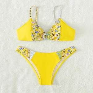Flat lay of yellow bikini with bohemian floral pattern on white plush background