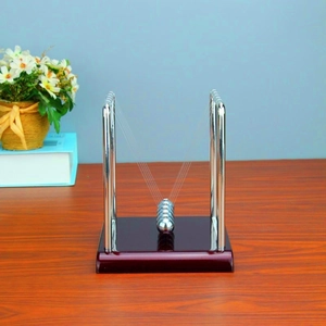 Detailed view of metal Newton's cradle on a wooden base for office desk physics decor