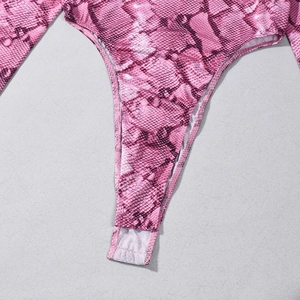 Gros plan sur la fermeture et la texture du tissu d'un body imprimé serpent rose