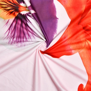 Gros plan sur un tissu floral doux avec des motifs de fleurs rose, orange et violet