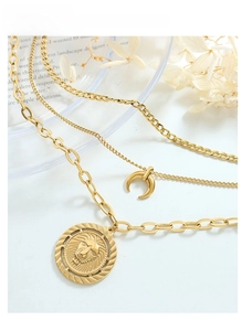 Detailed view of layered gold chains with lion head and crescent moon charms