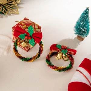 Detailed shot of Christmas wreath earrings with red velvet bow and golden bells