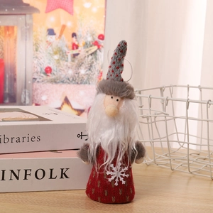Detail of a Christmas plush gnome with red knitted body and grey polka dot hat on a shelf