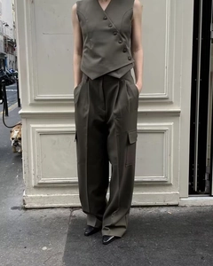 Detail of grey asymmetrical vest with side buttons and matching cargo pants set