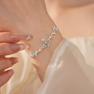 Nahaufnahme eines silbernen Schmetterlingsarmbands mit blauen Zirkonia am Handgelenk