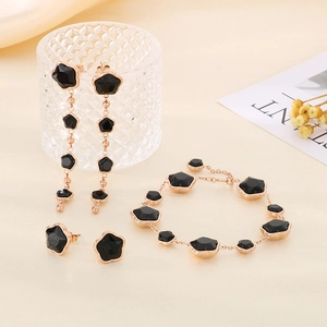 Parure de bijoux trèfle en or rose avec pierres noires comprenant boucles et bracelet