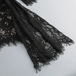 Gros plan sur un tissu en dentelle noire avec motifs floraux et bordure en cils