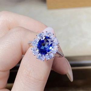 Macro shot of a S925 silver ring featuring an oval blue gemstone with halo diamonds