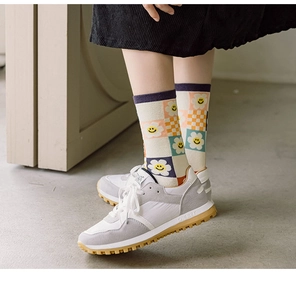Detailed macro view of argyle knit socks with smiley face and vintage sneakers
