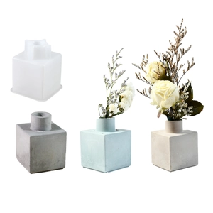 Close-up of cube block silicone mold and finished modern minimalist flower vases