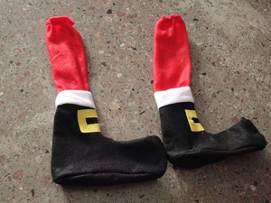 Detail view of Santa Claus themed Christmas table leg covers on a stone surface