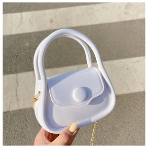 Close-up of white mini jelly bag with glossy finish and gold metal chain strap
