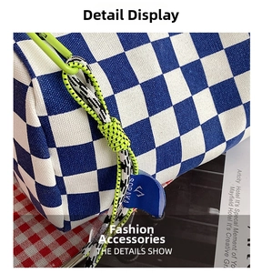 Detail of blue checkerboard canvas bag with green lanyard and brand logo tag