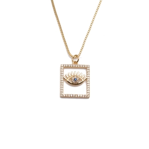Collana con ciondolo quadrato occhio del male dorato e zirconi blu e chiari su sfondo bianco