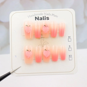 Faux ongles faits main dégradé pêche avec décorations 3D sur carte de présentation