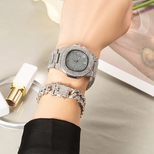 Close-up of iced-out silver watch and Cuban link bracelet set on a female wrist