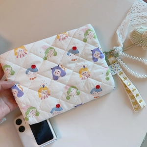 Detailed shot of quilted floral cartoon pouch with pearl handle and lace ribbons