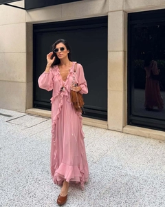Détail d'une robe en mousseline rose avec col en V, volants superposés et tissu léger