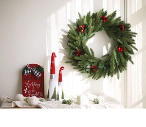 Close-up of Christmas wreath with red berries, pine cones and festive gnome dolls
